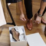 A casual man is trying on a new leather shoes